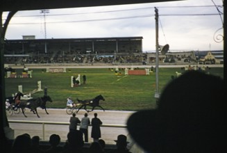 Trotting race in a stadium as part of an equestrian event, Melbourne, Victoria, Australia, 1956,