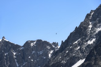 Gondola hovering in the air, in front of mountain peaks, mountain railway to the summit of the