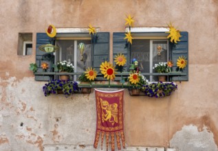 Windows decorated with flowers on a house facade, Venetian flag, Venice, Veneto, Italy, Europe