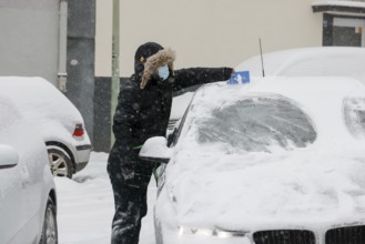 Essen, North Rhine-Westphalia, Germany - Onset of winter in the Ruhr area, driver with mask scrapes