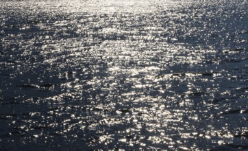 Sunbeams reflect glittering on water surface with high waves, Abstract background, Graphic