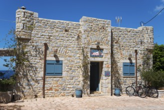 A stone house with a green door and a bicycle in front of it, Limeni, Areopoli, Laconia,