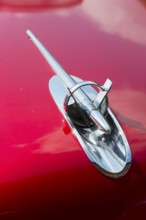 A shiny chrome radiator grille on the bonnet of a red classic car, detail Buick Eight, Ilsede,