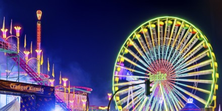 Cranger Kirmes with colourfully illuminated fairground rides and the Ferris wheel at night, Herne,