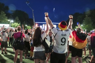 Fans cheer after the 1:0 win for Germany in the fan zone at the Brandenburg Tor during the round of