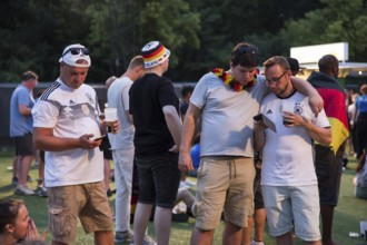 Fassball fans celebrate and gather information in the fan zone at the Brandenburg Tor after the