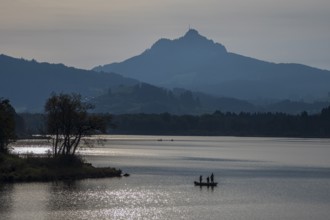 Lake Gruentensee, people fishing from a boat, Mt. Gruenten in the back, Wertach, Bavaria, Germany,