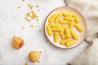 Jelly corn candies on gray concrete background and linen textile. top view, flat lay, close up