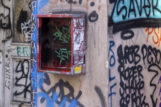 Defective chewing gum machine on a building in Berlin-Mitte, graffiti on the facade of a building.