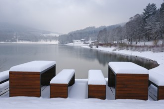 Rest area with snow-covered benches at the Hennesee, Hennetalsperre, Naturpark