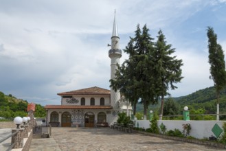 Mosque with decorative minaret, surrounded by trees and a fence, Melivia, Melivoia, centre of the