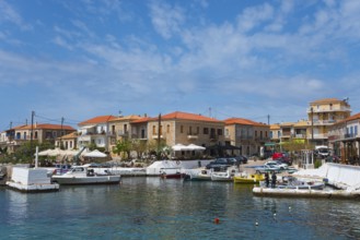 Harbour with boats and traditional buildings under a blue sky with some clouds, Agios Nikolaos,