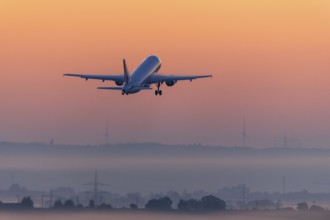 Passenger aircraft after take-off, in front of sunrise, fog, Baden-Württemberg, Germany, Europe