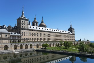 Historic stone monastery with reflection in the water and clear sky, Real Sitio de San Lorenzo de