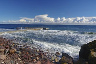 Coastal landscape with stormy waves on a rocky shore under a cloudy blue sky, Tönsberg, Oslofjord,