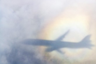 An aeroplane casts a shadow on a cloud, silhouette, halo rainbow. Germany