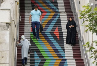 People walk down a painted staircase. The city of Tehran is changing the image of the city through