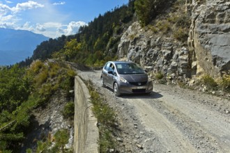 Car travelling on the unpaved mountain road between Ovronnaz and the hamlet of Chiboz, Valais,