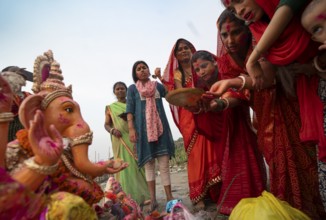 Devotees offer prayers to the Ganesha idol before immerse in the Brahmaputra river, during Ganesh