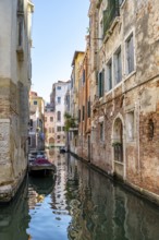 Narrow canal with boats, houses reflected in the water, Venice, Veneto, Italy, Europe