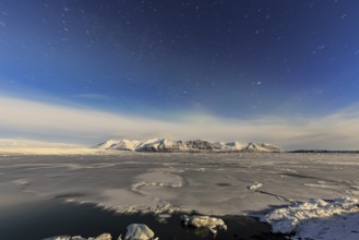 Night shot of an icy lake in front of Bergen, star trails, Vatnajökull, Jökulsarlon, Iceland,