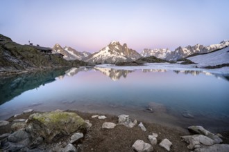 Evening mood with pink evening sky, mountain landscape with mountain hut Refuge du Lac Blanc at