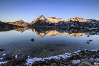 Fjord with steep snowy mountains, evening light, reflection, Flakstadoya, Lofoten, Norway, Europe