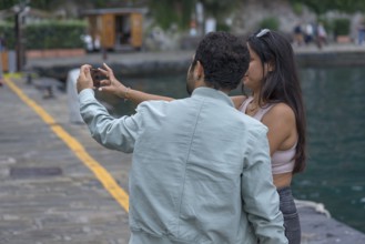 Couple taking a selfie of themselves in the harbour of Potofino, Italy, Europe