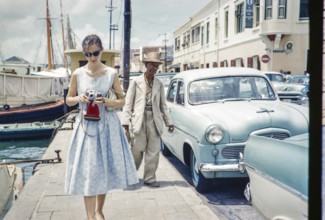 Tourist taking photographs in the fishing harbour, Willemstad, Curacao, Dutch Caribbean, early