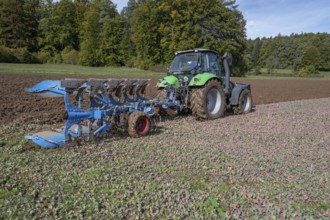 Farmer with tractor ploughing his field with a 5-turn rotary plough, Franconia, Bavaria, Germany,