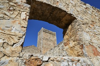 View through an arch of ruins to a clear sky and other stone structures, Flomochori, residential