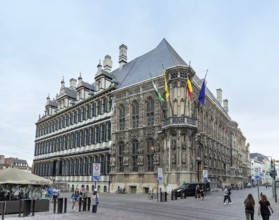 Majestic historic building with Gothic architecture and waving flags, Ghent