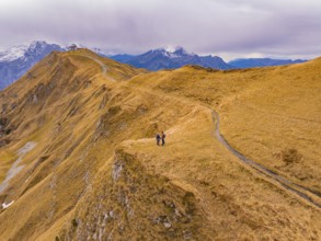 Two people on a hill path in a vast autumn landscape, Alpen Tower, Switzerland, Europe