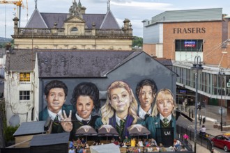 Mural on a building showing several young people in formal dress, Londonderry