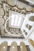 Modern interior with high ceiling, columns and a large circular structure in the centre, University