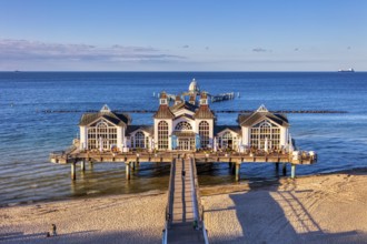 Symmetrical view of the pier with historic building above the blue sea and sand, Rügen, Sellin