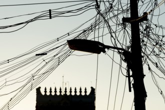 High-voltage power lines, tangle of cables, temple gopura or temple tower, Rameswaram or