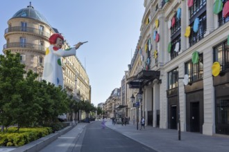 Modern art installation with large statue and colourful façade in an urban setting, Paris