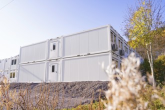 White container buildings with autumn trees in the surroundings, quiet atmosphere, refugee