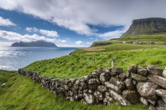 View of the island of Mykines, old stone wall, Gásadalur village, Vágar, Faroe Islands, Denmark,