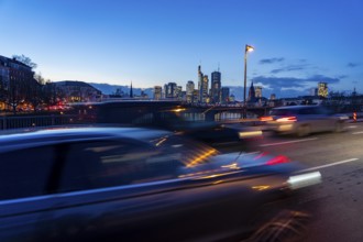 Skyline of the city centre of Frankfurt am Main, road traffic, car, on the raft bridge, dusk, river