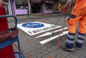 Application of road markings for a cycle lane, Rüttenscheider Straße in Essen, in the shopping and