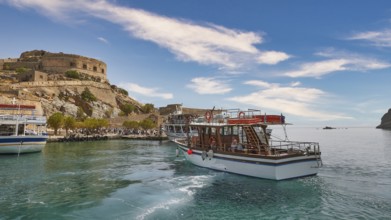 A white boat lies in a quiet harbour near a historic fortress under a blue sky, Venetian Sea