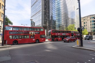 City scene with several red double-decker buses and modern skyscrapers in London, United Kingdom