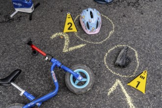 Markings at an accident scene with a balance bike for children, helmet, reenacted accident