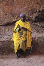 Rock churches of Lalibela, pilgrim prays with a rosary in front of a rock church, Ethiopia, Africa