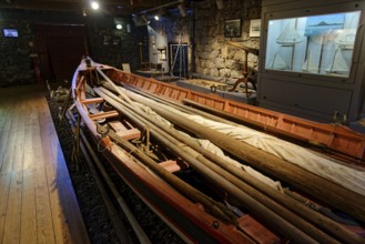 Long, narrow whaling boat in the whaling museum Lajes do Pico, with oars and harpoons, fishing