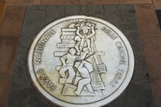 Round white marble plaque inscribed with the Italian words Parco Nazionale Delle Cinque Terre