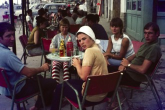 Group of young British people on holiday sitting around a cafe table, Spain, 1966, Europe