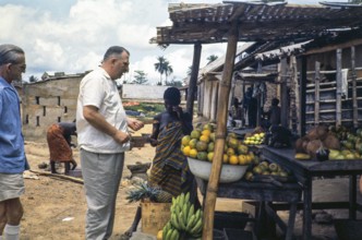 European emigrant buying fruit at a street market, Sierra Leone, West Africa 1963 1964, Africa